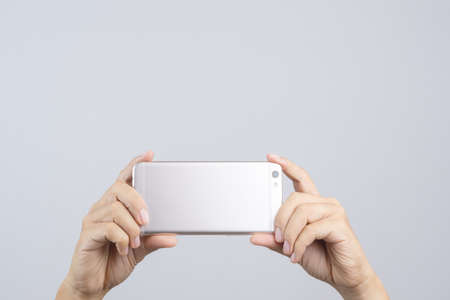 Hand taking a photo or video by mobile phone on white backgroundの写真素材