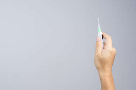 Hand holding Illuminated ear pick with built in electric light on white backgroundのeditorial素材