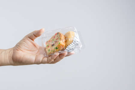 Hand holding traditional fruit cake with raisin, cinnamon and dried cranberries  packed with baked...