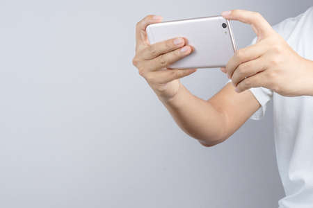 Hand taking a photo or video by mobile phone on white backgroundのeditorial素材