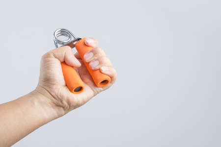 Hand exercising strength using hand gripper on white backgroundのeditorial素材