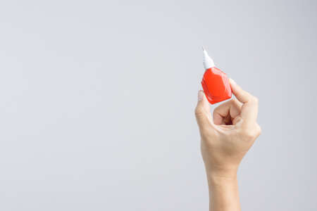 Hand holding correction pen or liquid paper for correct hand writing mistakes on white backgroundの写真素材