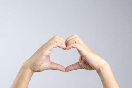 Hand making a heart shape, love and relationship gesture concept on white backgroundの写真素材