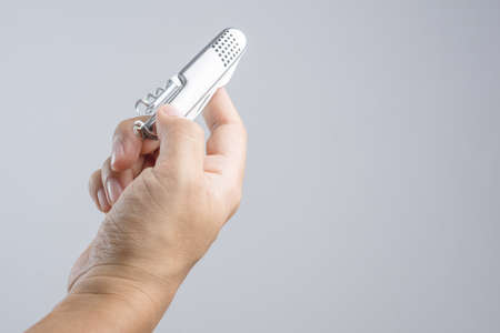 Hand holding silver folding Swiss  army knife, pocket universal tools for multi functions on white backgroundの写真素材