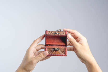 Hand holding small leather treasure chest box on white backgroundの写真素材