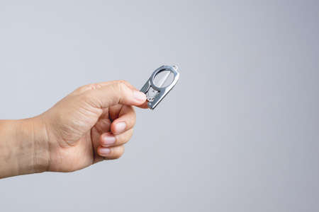 Hand holding mini folding scissors for traveling on white backgroundの写真素材