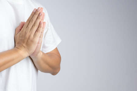 Hand making buddhist pray gesture or greeting culture, Wai, in Thailand on white backgroundの写真素材