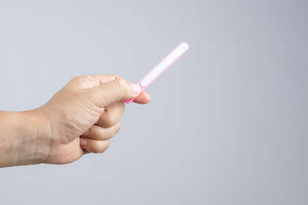 Hand holding nail file for manicuring and pedicure, a cosmetic tool on white backgroundの写真素材