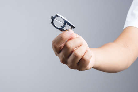 Hand holding mini folding scissors for traveling on white background