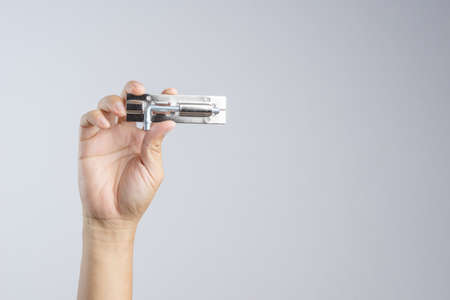 Hand holding shiny silver color stainless steel door bolt lock or latch on white background