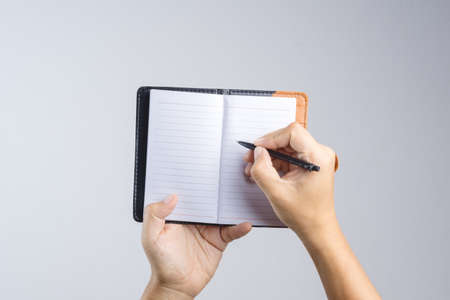 Hand holding vintage brown cover paper notebook on white backgroundの写真素材
