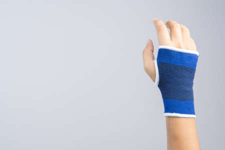 Hand with elastic wrist support and hurt gesture on white backgroundの写真素材