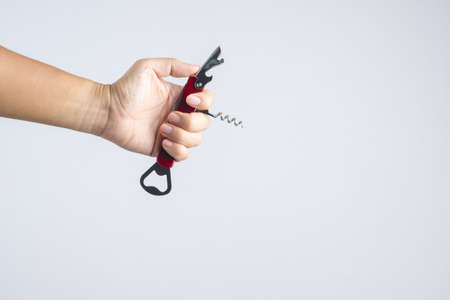 Hand holding pocket universal bottle opener with short knife for multi functions on white backgroundの写真素材