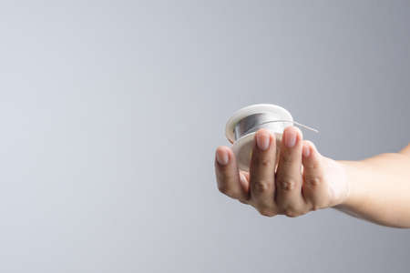 Hand holding solder wire roll for soldering in electronic equipment on white backgroundの写真素材