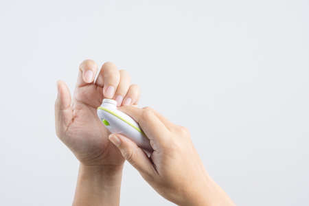 Hand holding finger nails cutter buffing or polishing kit for kid, self manicure process on white backgroundの写真素材