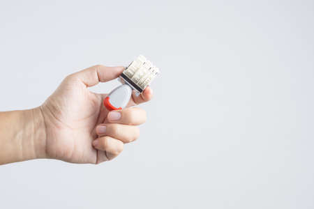 Hand holding date months years stamper on white backgroundの写真素材