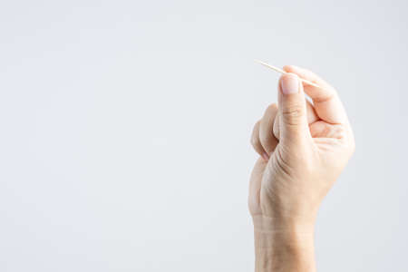hand holding bamboo or wooden toothpick on white backgroundの写真素材