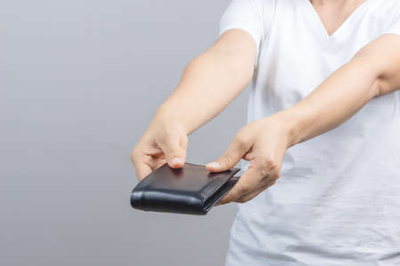 Woman hand holding man wallet on grey backgroundの写真素材