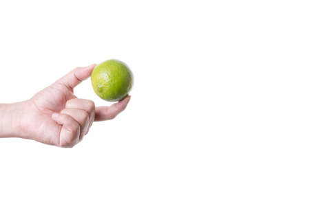 Hand holding a fresh lime on white background