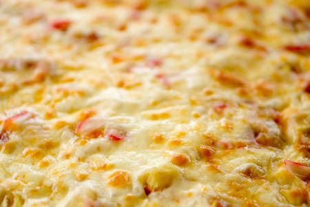 Baked cheese crumbles over homemade pizzaの写真素材