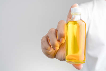 Hand holding  Thai Boxing Liniment or Namman Muay use for massage to relieve muscles, tendons,...