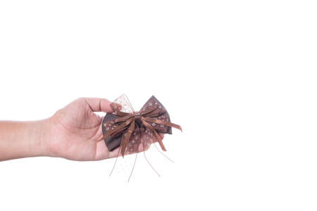 Hand holding brown hair ribbon bow on white backgroundの写真素材