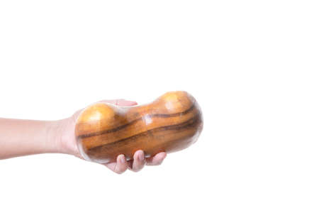 Hand holding teak wood carved in woman breast shape for massage use