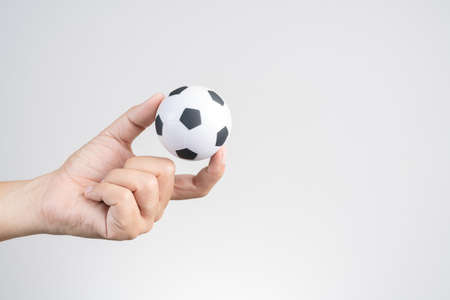Hand holding small soccer ball or football on white backgroundの写真素材