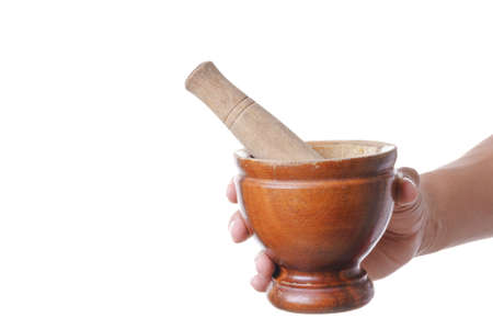 Hand holding wooden mortar and pestle made of wood on white backgroundの写真素材
