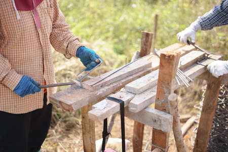 Asian worker bending metal at house construction site using only hands and simple equipmentの写真素材