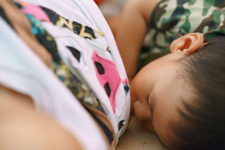 Asian boy about 1 year and 11 months old Asian baby breastfeeding before wake up in the morningの写真素材