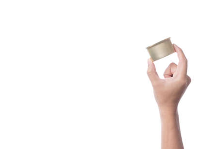Hand holding tin or steel can made of aluminium for food on white backgroundの写真素材