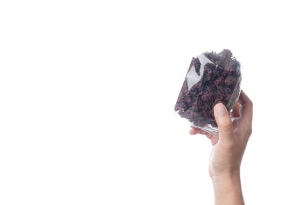 Hand holding pack of dried red roselles for making a herbal tea on white backgroundの写真素材