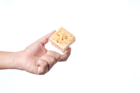 Hand holding khao soi tud, traditional Thai snack in plastic bag on white backgroundの写真素材