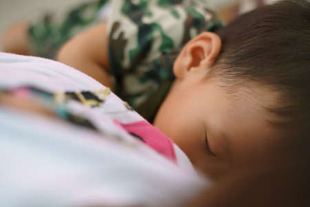 Asian boy about 1 year and 11 months old Asian baby breastfeeding before wake up in the morningの写真素材