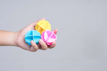 Hand holding laundry plastic ball for washing machine on white background