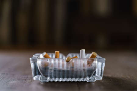 Glasses cigarette ash tray on wooden tableの写真素材