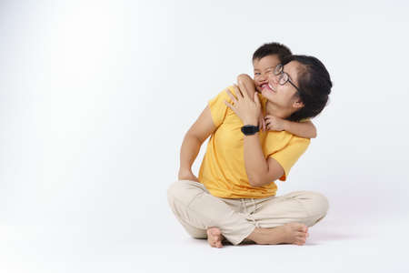 Happy Asian mother and her 2 years and 8 months son playing on white background
