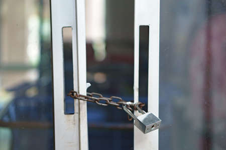Modern lock with steel chain on broken door