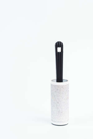 Adhesive lint roller with sticky paper full of hair and dust on white backgroundの写真素材