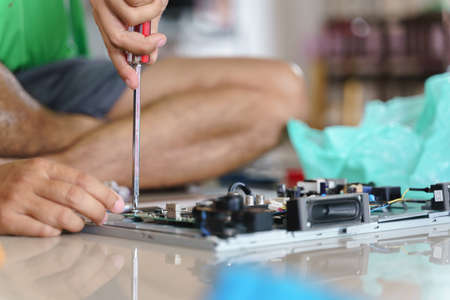 Hand fixing broken electronic board or pcb with soldering at homeの写真素材