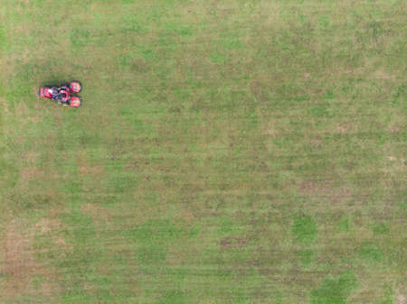 Mower cutting grass at soccer or football field in stadiumのeditorial素材