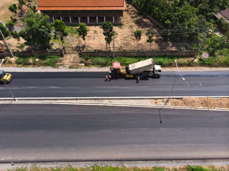 Asphalt machine and steamroller operator job at new road construction siteのeditorial素材