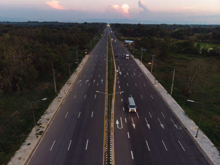 Highway road next to green rice field in Asian countryの写真素材