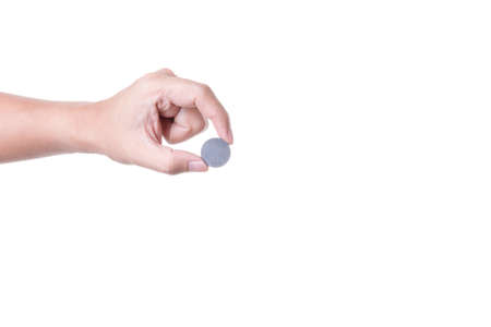 Hand holding round black metal magnet