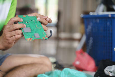 Hand fixing broken electronic board or pcb with soldering at homeの写真素材