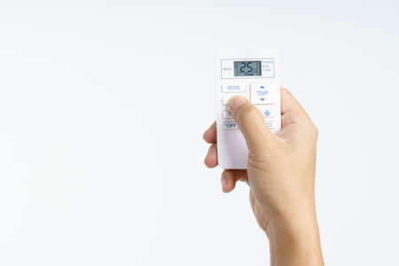 Hand holding air conditioner remote set temperature at 25 celsius on white background