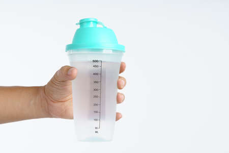 Hand holding plastic water bottle with 500ml gauge on white background
