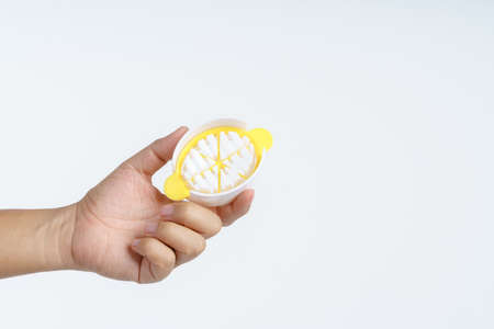 Hand holding plastic boiled egg slicer on white background