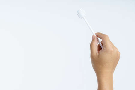 Hand holding plastic honey dipper stick on white backgroundの写真素材